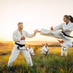Female karate fighter trains kick in flight